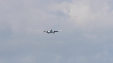 Bulutlu bir gökyüzüne iniş yapmak üzere tanımlanamayan bir üniforması olan ticari jet. Uçak yaklaşıyor. Seyahat kavramı