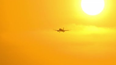 Şaşırtıcı bir altın gün batımında bir uçak siluetinin sinematik görüntüleri. Seyahat kavramı