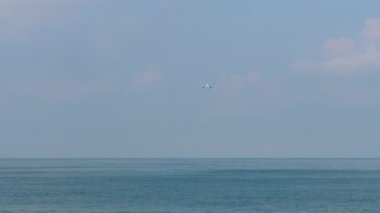 Uzun menzilli bir jet uçağı denize inmek için yaklaşıyor. Seyahat kavramı