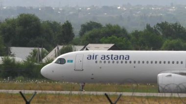 ALMATY, KAZAKHSTAN - 24 Haziran 2024: Almaty havaalanında Astana Hava Taşıyıcısı. Taksideki bir uçak. Uçak geliyor.
