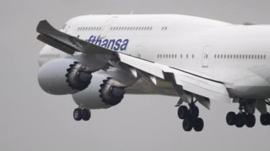 FRANKFURT AM MAIN, ALMANY - 20 Temmuz 2017: Jumbo jet Boeing 747, Lufthansa iniş D-ABYQ, piste dokunuyor ve Frankfurt havaalanında fren yapıyor, yan görüş. Beneklenme