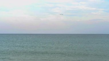 Okyanusa inen bir jet uçağı. Gökyüzünde bir uçak, uzak ihtimal. Seyahat ve tatil sahnesi.