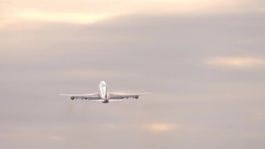 Güzel bir gün batımı ya da gün doğumu gökyüzünde irtifa kazanan dört motorlu bir arabanın görüntüsü