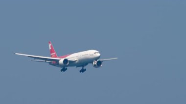 PHUKET, THAILAND - 20 HAZİRAN 2025: Ikar Boeing 777, RA-73272 Phuket havaalanına iniyor. Uçak uçuşu, yan görüş. Seyahat kavramı