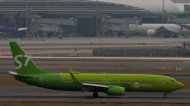 BANGKOK, THAILAND - 17 Mart 2025: yan görüş, uçak S7 Airlines, Boeing 737 Suvarnabhumi havaalanına varıyor. Seyahat kavramı