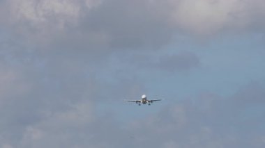 İniş yapmadan önce gökyüzüne inen yolcu uçağının uzaktan görüntüsü. Hava yolculuğu kavramı.