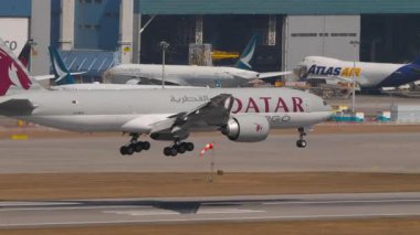 HONG KONG - 29 Ocak 2025: Boeing 777, Katar Kargo A7-BFX Chek Kap Kok havaalanına iniş, yan görüş. Kargo jeti geliyor. Beneklenme