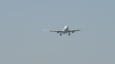 Jet yolcu uçağı iniş için yaklaşıyor. Gökyüzünde bir uçak. Havacılık, seyahat, hava taşımacılığı ve ticari uçuşlar kavramı