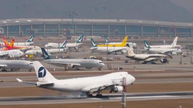 HONG KONG - 29 Ocak 2025: Challenge Airlines Boeing 747, 4X-ICA Chek Kap Kok havaalanına indikten sonra fren yapıyor, Hong Kong. Kargo jumbo jeti geliyor, yan görüş. Beneklenme