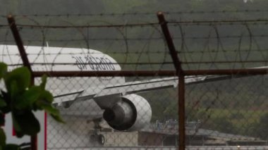 PHUKET, THAILAND - 24 Şubat 2025: Boeing 767, Air Astana 'dan EI-KEA, Phuket Havaalanı' nda yağmurda havalanır. Seyahat kavramı