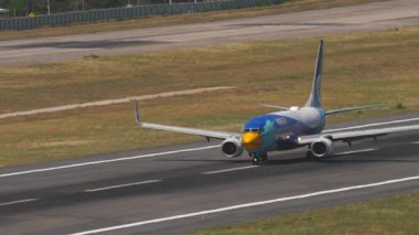 PHUKET, THAILAND - 12 Mart 2025: Boeing 737, Nok Air 'den HS-DBP piste çıkıyor, yan görüş. Uçak geliyor. Seyahat kavramı