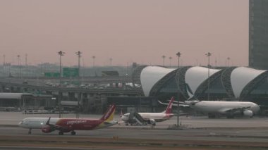 BANGKOK, THAILAND - 15 Mart 2025: Vietnam JetAir Tayland Airbus A321, HS-VKJ Suvarnabhumi havaalanında taksicilik. Terminaldeki uçakların sinematik görüntüleri. Seyahat kavramı