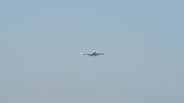 Tanımlanamayan bir üniforması olan büyük bir uçak iniş yapmak üzere. Mavi gökyüzü arka planında bir uçak. Seyahat kavramı