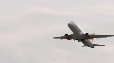 ALMATY, KAZAKHSTAN - 25 Haziran 2024: Azimuth 'un yolcu jeti Sukhoi Superjet 100 havalanıyor, iniş takımları açılıyor. Uçak tırmanışı. Seyahat konsepti. Beneklenme