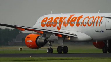 AMSTERDAM, NETHERLANDS - 25 Temmuz 2017 Airbus A320 Easy Jet, G-EZDB yolcu uçağı havalandı. Uçak uçup gidiyor. Seyahat kavramı