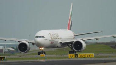 AMSTERDAM, NETHERLANDS - 25 HAZİRAN 2017: Geniş gövdeli uçak Emirates kargo Boeing 777, A6-EFO piste, orta menzilli, yan görüş