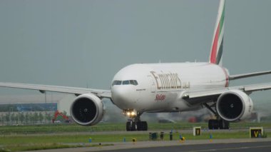 AMSTERDAM, NETHERLANDS - 25 Temmuz 2017: Emirates Kargo Boeing 777, plakası A6-EFO, havaalanındaki pistte taksicilik. Havacılık, kargo ve ulaşım temaları için ideal