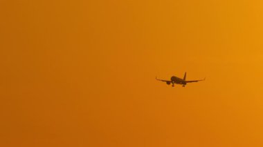 Göz kamaştırıcı altın bir gün batımında bir uçak siluetinin güzel görüntüleri. Seyahat kavramı