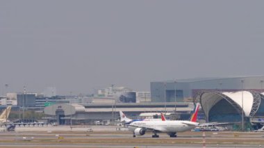 BANGKOK, THAILAND - 16 Mart 2025: Filipin Havayolları Boeing 777, RP-C7774 Suvarnabhumi Havaalanı 'nda taksicilik. Taksideki uçağın yan görüntüsü. Havacılık ve seyahat teması.