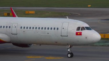 CHANGI, SINGAPORE - 30 HAZİRAN 2025: VietJetAir Airbus A321, VN-A683 Singapur Changi havaalanında taksicilik. Seyahat konsepti. Beneklenme.
