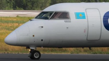 ALMATY, KAZAKHSTAN - 25 Haziran 2025: Kazaq Hava Bombacısı DHC-8-400, UP-DH004 pistte, yan görüş. Havacılık, ulaşım ve seyahat temaları