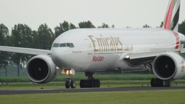 AMSTERDAM, NETHERLANDS - 25 Temmuz 2017: Geniş gövdeli Emirates kargo uçağı Boeing 777, pistte A6-EFO, orta atış. Havaalanında büyük bir nakliye uçağı.