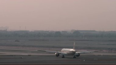 BANGKOK, THAILAND - 15 Mart 2025 Etihad Havayolları Boeing 777, Suvarnabhumi Havaalanı 'nda taksicilik. Havaalanında geniş gövdeli uçak. Seyahat kavramı