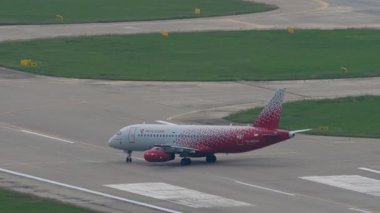 SOCHI, RUSSIA - 02 AĞUSTOS 2022: Rossiya 'dan Sukhoi Superjet 100, Adler Havaalanı, Sochi' deki piste gidiyor. Yolcu uçağı kalkıyor. Seyahat kavramı
