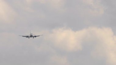 Ticari yolcu uçağı öğleden sonra bulutlu havada iniş için piste yaklaşır. Seyahat kavramı