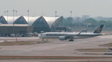 BANGKOK, THAILAND - 16 Mart 2025: Airbus A350 Singapur Havayolları Suvarnabhumi Havaalanı 'nda taksicilik. Havacılık ve seyahat teması.