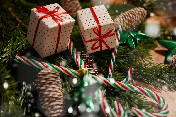 クリスマスプレゼントを開く 木製の机の上にギフトボックスを開く男のクローズアップビューでは クリスマスの装飾が周りに横たわっている — ストック写真
