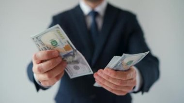 Formally dressed man counting US Dollar bills, close-up. Concept of investment, success, financial prospects or career advancement. Slow motion