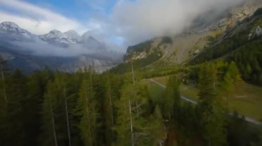 İsviçre Alpleri 'ndeki Oeschinensee Gölü üzerinde bulutlu bir sonbahar gününde FPV manevra kabiliyeti olan bir uçuş. Kandersteg, İsviçre.