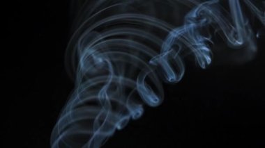 Soyut duman siyah arka planda güzel girdaplarda yükselir. Yavaş çekim. 