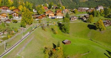 İsviçre 'nin güzel doğası ve Lauterbrunnen köyünün havadan görünüşü, tren, dağ yolunda yavaş ilerliyor. Ünlü İsviçre turizm beldesi.