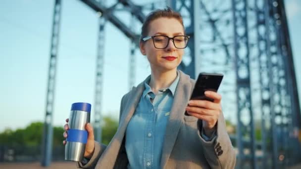 コートを着た白人の実業家が早朝に街を歩き コーヒーを飲み スマートフォンを使用している コミュニケーション 仕事の日 忙しい生活の概念 — ストック動画