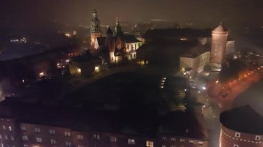 Krakow, Polonya 'daki Wawel Kraliyet Kalesi' nin sisli bir gecede hava görüntüsü. Kraliyet Wawel Kalesi gece aydınlandı.. 