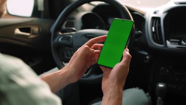 男司机在车里用智能手机 带有绿色屏幕的Chromakey智能手机 自动导航 上网成瘾 汽车保险申请 — 图库视频影像