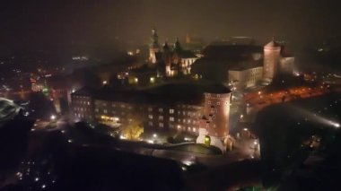 Krakow, Polonya 'daki Wawel Kraliyet Kalesi' nin sisli bir gecede hava görüntüsü. Kraliyet Wawel Kalesi gece aydınlandı.. 