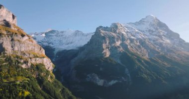 İsviçre 'nin Grindelwald Vadisi' ndeki güzel İsviçre doğasının hava manzarası, İsviçre 'nin Jungfrau bölgesindeki Alpler' de gün batımı, ünlü İsviçre turizm beldesi.