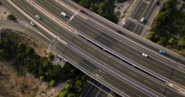 Hareket halindeki arabalarla kavşağın üst tarafı. Yol kavşağı ya da yol kavşağı. Yoğun şehir trafiği yolda hız yapıyor. Kamera saat yönünün tersine döner