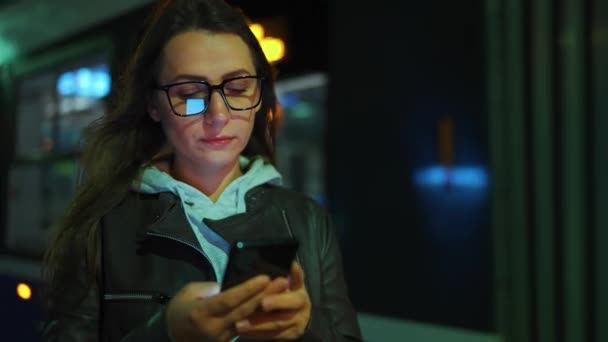 Woman Stands Public Transport Stop Night Using Smartphone Waiting Tram — Vídeo de Stock