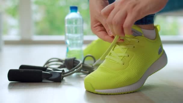 トレーニングやジョギングに行くスニーカーに靴ひもを結ぶ女性 閉じる — ストック動画