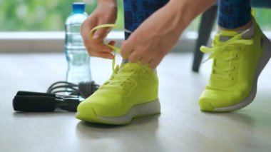 Ayakkabı bağcığını bağlayan kadın antrenmana ya da koşuya gidiyor, kapat..