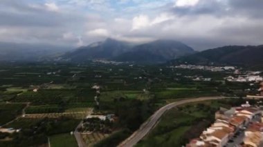 Denia şehrinin yakınlarındaki bölgede hava hipervanesi. Bulutlar dağın üzerinde yüzüyor, turuncu alanlar, dağların eteğindeki köyler. Alicante ili, İspanya