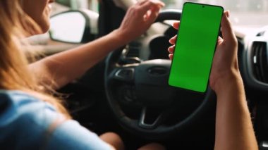 Kadın sürücü arabanın içinde akıllı telefon kullanıyormuş. Yeşil ekranlı Chromakey akıllı telefon. Otomatik navigasyon. İnternet bağımlılığı. Otomobil sigortası uygulaması.