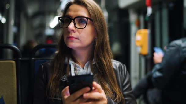 Public Transport Night Woman Glasses Tram Using Smartphone Chatting Texting — Stockvideo