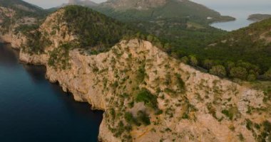 Scenic aerial view of a mountainous region in Majorca with cliffs. Panoramic view of Mirador Es Colomer in Sierra de Tramuntana and blue sea, Balearic Islands, Spain.