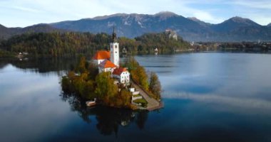 Aerial view of lake Bled and the island in the middle of it, Slovenia. Pilgrimage Church of the Assumption of Mary In Lake Bled. Shotted with different speed - accelerated and normal