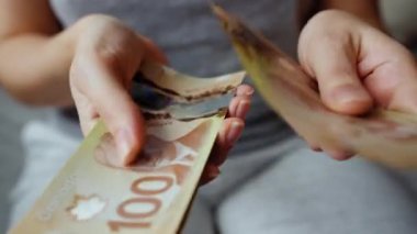 Female hands counting Canadian Dollar bills, close-up. Concept of investment, success, financial prospects or career advancement.